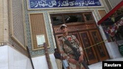  巴基斯坦信德省一座苏菲派清真寺发生自杀炸弹爆炸后，民兵在入口处站岗(2017年2月17日)