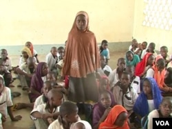 While waiting for their teachers to return, Cameroonian students are relying on lessons taught by humanitarian workers and military personnel. Here, a young girl answers her substitute teacher's question in Fotokol, May 11, 2018. (M. Kindzeka/VOA)