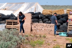 Funcionarios del Departamento de Planeación del Condado de Taos, Rachel Romero, izquierda, y Eric Montoya inspeccionaron las condiciones de propiedad en un desvencijado complejo residencial en Amalia, N.M., el martes 7 de agosto de 2018.