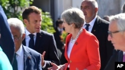 French President Emmanuel Macron (L) talks with British Prime Minister Theresa May when arriving for a family photo at the informal EU summit in Salzburg, Austria, Sept. 20, 2018. 