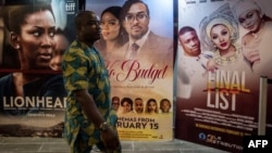 A man passes by Nigerian movie billboards at a cinema in Lagos, Feb. 19, 2019. 