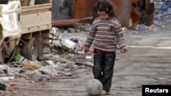 지난달 30일 시리아 홈스의 폐허 속에서 어린이가 공을 차며 놀고 있다.