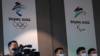 Reporters are seen in front of the Beijing 2022 Winter Olympic and Paralympic Games signs during a news conference on the construction progress of the sports event venues, at the headquarters of the Beijing Organising Committee, in Beijing, China July 30…