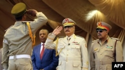 Le maréchal Khalifa Haftar, au centre, salue le chef d'état-major de l'armée nationale libyenne Abdelrazak al-Nadhuri, à droite, et l'ancien Premier ministre libyen Abdullah al-Thani, chef du gouvernement à Bayda, lors d’une parade militaire à Benghazi, L
