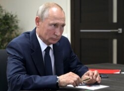 Russian President Vladimir Putin listens to deputy Prime Minister Yuri Borisov during their meeting after visiting the Zaliv shipyard in Kerch, Crimea, July 20, 2020.