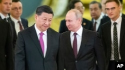 FILE - President Vladimir Putin, right, and President Xi Jinping enter a hall for the talks in the Kremlin in Moscow, Russia, June 5, 2019.