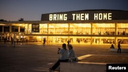 Ljudi razgovaraju ispred natpisa koji se odnosi na taoce otete tokom smrtonosnog napada palestinske islamističke grupe Hamas 7. oktobra, u Tel Avivu, Izrael, 2. juna 2024.