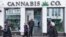 FILE - People pass by a cannabis shop in midtown Manhattan in New York on March 19, 2024. 