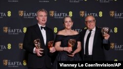 S lijeva, reditelj Christopher Nolan i producenti Emma Thomas i Charles Roven, dobitnici nagrade za najbolji film za 'Openheimer', poziraju za fotografije na 77. dodjeli filmskih nagrada Britanske akademije, u Londonu, 18. februara 2024. (Foto: Vianney Le Caer/Invision/AP)