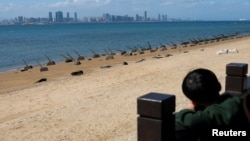 一个男孩从台湾金门岛海岸遥望中国厦门市。（2024年2月21日）