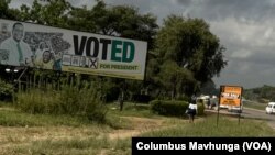 A Zimbabwean walks past a poster with the photo of President Emmerson Mnangagwa in Harare, Zimbabwe, on Feb. 5, 2024.
