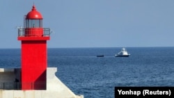 一艘韩国军舰拖着一只据信是逃出朝鲜的脱北者乘坐的小木船前往韩国襄阳港口。（2023年10月24日）