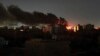 Smoke rises over the horizon as a fire burns after a strike in Khartoum, Sudan, April 16, 2023.