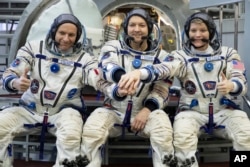 FILE - From left, CSA astronaut David Saint Jacques, Russian cosmonaut Оleg Kononenko‎, and U.S. astronaut Anne McClain pose for a photo before preflight examinations on Wednesday, Nov. 14, 2018. (AP Photo/Pavel Golovkin, File)