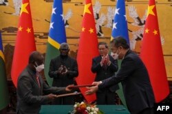 中国总理李强与所罗门群岛总理索加瓦雷在北京人大会堂出席一个签字仪式。（2023年7月10日）