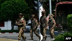 缅甸军事安全部队成员2024年2月1日在抗议三年前军事政变的“无声罢工”期间在街道上巡逻。（法新社照片）