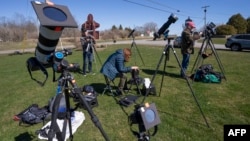 የካሜራ ባለሞያዎች መሳሪያቻቸውን እየፈተሹ በሰሜን አሜሪካ የፀሐይ ግርዶሽ ዋዜማ ማምሻ ላይ፣ በኬፕ ቪንሰንት፣ ኒው ዮርክ፣ እአአ ሚያዝያ 7/2024