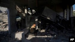 ຊາວປາແລັສໄຕນ໌ ພວມກວດເບິ່ງຄວາມເສຍຫາຍເຮືອນຫຼັງນຶ່ງ ຫຼັງຈາກຖືກໂຈມຕີທາງອາກາດໂດຍອິສຣາແອລ ໃນເຂດ ເດຍ ອາລ ບາລາ ຂອງກາຊາ, ວັນທີ 4 ທັນວາ 2023.