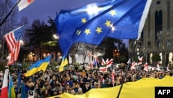格鲁吉亚民众在首都第比利斯街头举着乌克兰、欧盟和美国的旗帜游行纪念俄乌战争爆发两周年。（2024年2月24日）