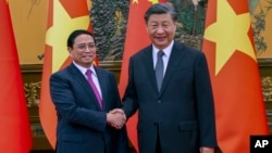 资料照片: 2023年6月27日越南总理范明正(左)在北京会晤中国国家主席习近平