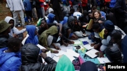 Several volunteers give Spanish classes to migrants outside the Las Raices Camp in La Laguna, Spain, November 5, 2023. (REUTERS/Borja Suarez)