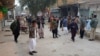 Security personnel and people gather near the site of a bomb explosion at Sibi, in Baluchistan province, Jan. 30, 2024. 