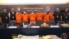 Indonesian police officers escort suspects and display the items of evidence during a press conference at Jakarta police headquarters in Jakarta, Indonesia, Thursday, July 20, 2023.