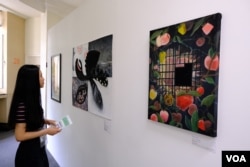 参展者“煲儿”其中一幅显示被封禁的苹果，但在铁闸以后，却生出不少新的苹果 (美国之音/郑乐捷)