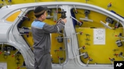FILE - A worker examines a car frame at a Vinfast factory in Hai Phong, Vietnam on Sept. 29, 2023. (AP Photo/Hau Dinh)