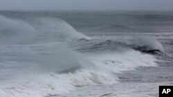 FILE - Wind blown waves from Hurricane Florence hit the beach in Emerald Isle N.C., Thursday, Sept. 13, 2018. (AP Photo/Tom Copeland)