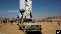 ২০২৪ সালের ২৯ জানুয়ারি হুথি যোদ্ধারা সানায় একটি সমাবেশে হুথি আন্দোলনের নেতা আবদেল মালেক আল-হুথির একটি পোস্টার প্রদর্শন করছে।