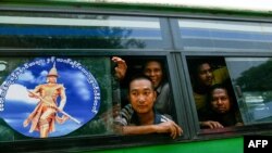 Para tahanan duduk di dalam bus selama pembebasan mereka dari penjara Insein untuk merayakan Tahun Baru Budha, di Yangon, 17 April 2024. (AFP)