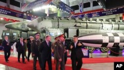 在朝鲜政府提供的这张照片中，朝鲜领导人金正恩（右）与国防部长谢尔盖·绍伊古率领的俄罗斯代表团于 2023 年 7 月 26 日在朝鲜平壤参观武器展览。