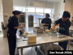 Participants at the Delaware Food Bank culinary school in Newark, DE, prepare cheese as a part of class, on February 4, 2024. (Dan Novak/VOA)