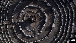FILE - Brazilian tourists hold hands standing in a circle in the Pueblo Encanto park in Capilla del Monte, Argentina, July 19, 2023. Known as the "nones," they describe themselves as atheists or "nothing in particular." (AP Photo/Natacha Pisarenko, File)