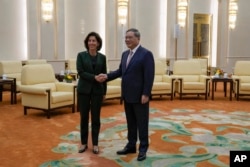 FILE - U.S. Commerce Secretary Gina Raimondo, left, shakes hands with Chinese Premier Li Qiang before their meeting at the Great Hall of the People in Beijing, Tuesday, Aug. 29, 2023. (AP Photo/Andy Wong, Pool)