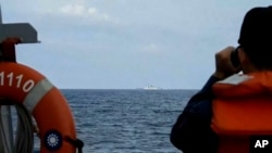 2023年8月19日，台湾国防部发布的视频截图，一名台湾海军水手在成功级巡防舰“田单号”上在台湾沿海监视中国海军舰艇“徐州舰”。（美联社照片）