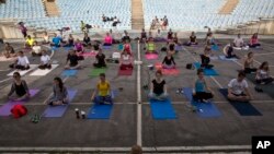 FILE - Para pelajar mengikuti pelajaran yoga di luar ruangan yang diadakan di Taman Nasional Germia di ibu kota Kosovo Pristina, 16 Juni 2016. (AP Photo/Visar Kryeziu)