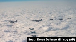 韩国国防部发布照片显示美日韩战机在三方联合军演中飞越韩国济州岛上空。（2023年12月20日）