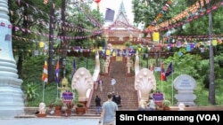 មនុស្សម្នា​នាំ​គ្នា​ដើរ​នៅ​ពី​មុខ​កាំជណ្តើរ​ឡើង​ទៅ​វត្តភ្នំ​ ដែល​មាន​ការ​តុបតែង​លម្អ​សម្រាប់​អបអរ​ពិធី​បុណ្យ​ចូលឆ្នាំ​ប្រពៃណី​ជាតិ​ខ្មែរ ក្នុង​រាជធានី​ភ្នំពេញ នៅថ្ងៃទី១៣ ខែមេសា ឆ្នាំ២០២៣។ (ស៊ឹម ចាន់សំណាង/វីអូអេ)