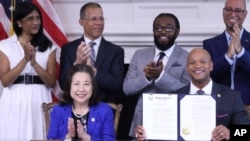 FILE - Maryland Gov. Wes Moore holds up an executive order he signed to issue more than 175,000 pardons for marijuana convictions in Annapolis, Maryland, June 17, 2024. 