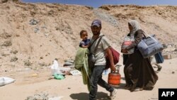 Palestinci nose svoje stvari dok bježe iz improviziranog kampa za raseljene u Khan Yunisu u južnom pojasu Gaze nakon što su izraelski tenkovi zauzeli položaj na brdu s pogledom na to područje, 18. avgusta 2024.