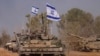 Israeli army vehicles arrive to an staging area after combat in the Gaza Strip in southern Israel, Dec. 30, 2023.