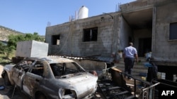 ইসরাইল অধিকৃত পশ্চিম তীরের রামাল্লার কাছে আল-মুঘাইর গ্রামের একটি বাড়ির ক্ষয়ক্ষতি দেখছেন একজন ফিলিস্তিনি নাগরিক, ১৩ এপ্রিল ২০২৪। 