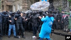 Policia ndërhyn për të bllokuar protestuesit t'i afrohen parlamentit gjatë protestës opozitare kundër ligjit "për agjentët e huaj", 13 maj 2024, Tbilsi, Gjeorgji