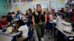 Third grade teacher Megan Foster walks through her classroom as students take a break from a reading lesson, Tuesday, April 16, 2024. (AP Photo/Rebecca Blackwell)