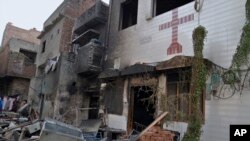 Lokalno stanovništvo gleda ruševine kuća i crkava koje je vandalizirala bijesna muslimanska masa u kršćanskoj oblasti u Jaranwala u okrugu Faisalabad, Pakistan, četvrtak, 17. avgusta 2023.