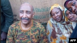 সেনাবাহিনী প্রধান জেনারেল আব্দুল ফাত্তাহ আল-বুরহান খার্তুমের বেসামরিক ব্যক্তিদের সঙ্গে ছবিতে পোজ দিচ্ছেন;(সুদানের সশস্ত্র বাহিনীর ফেসবুক ছবি); ২৪ আগস্ট ২০২৩। 