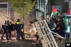 In this image taken from video, police arrests some 125 activists as they broke up a pro-Palestinian demonstration camp at the University of Amsterdam in Amsterdam, the Netherlands, Tuesday, May 7, 2024. (AP Photo InterVision)