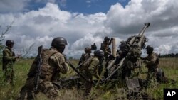 Украинские военные готовятся к обстрелу российских позиций из гаубицы M777, поставленной США, в Харькове, Украина, 14 июля 2022 г.